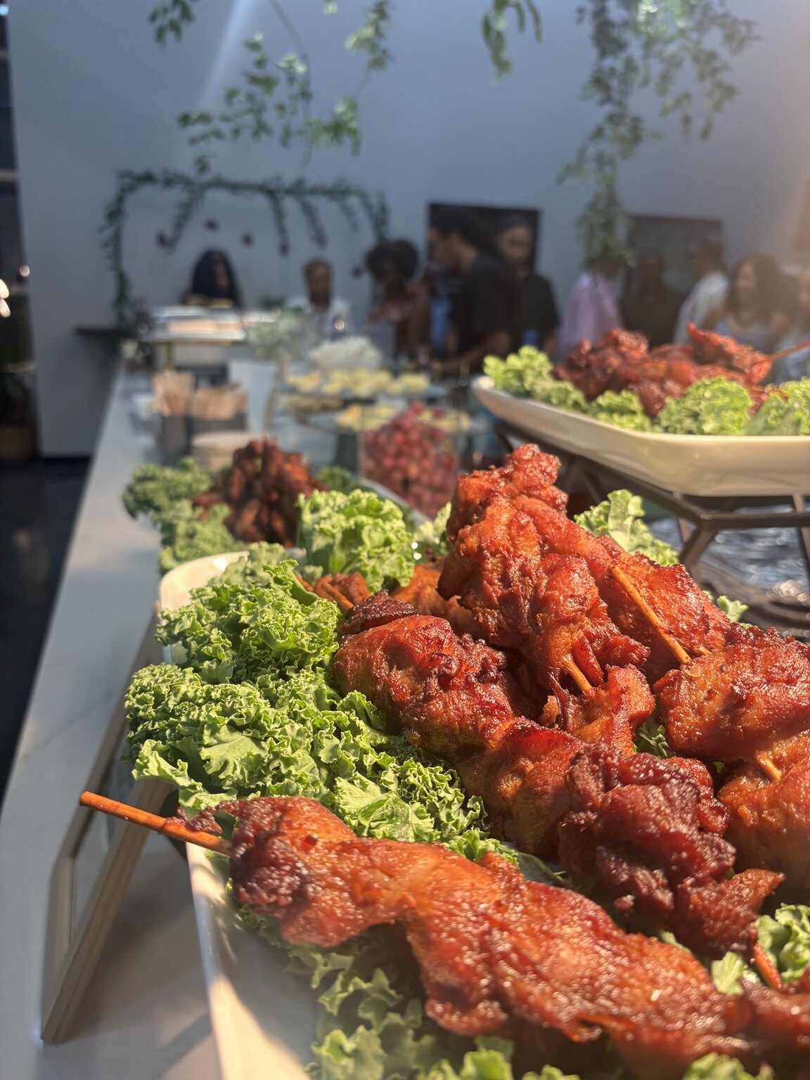 Glazed skewers arranged with fresh greens for catered service
