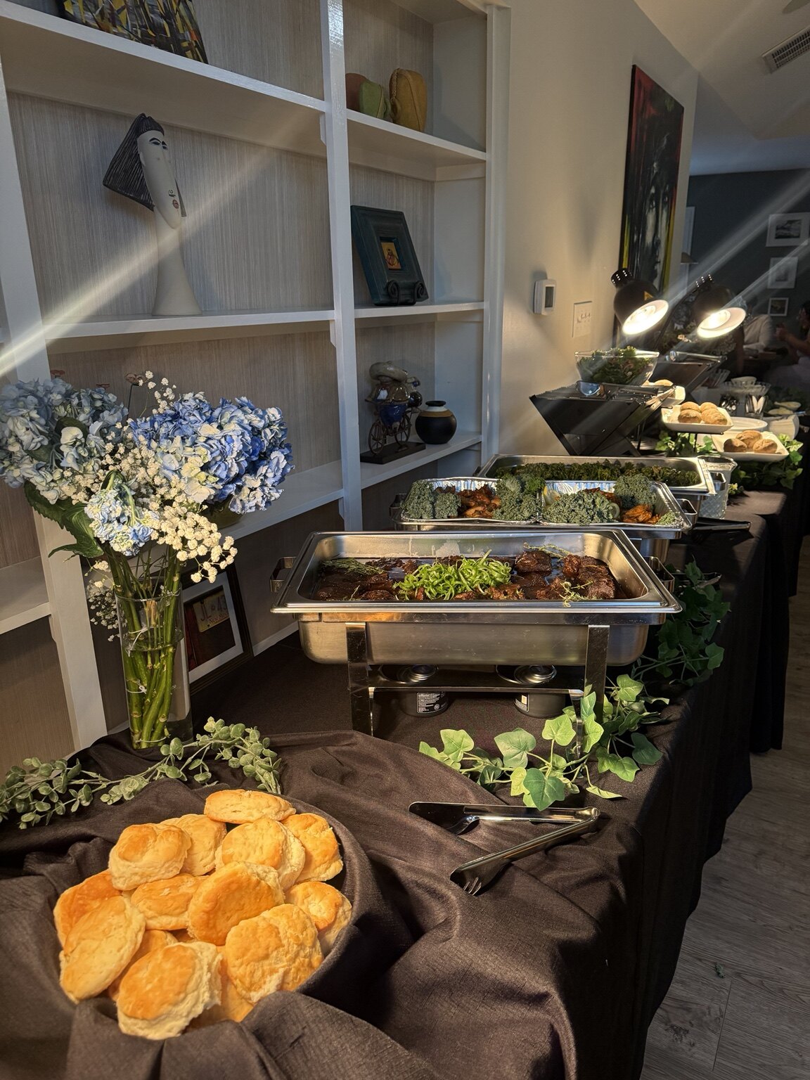 A DeeLish catered buffet with fresh biscuits, florals, and hot entrées