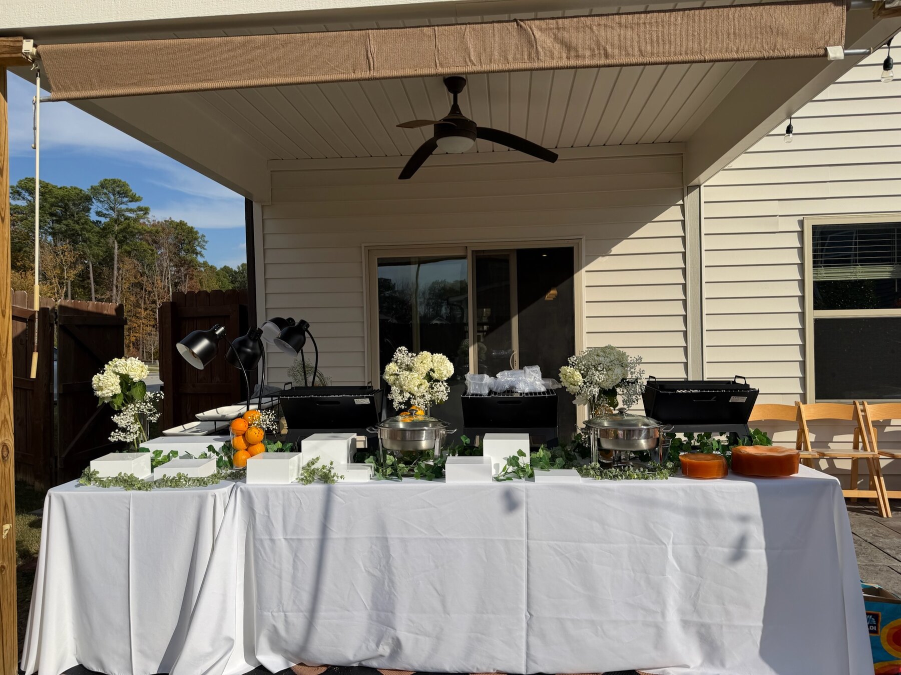 An outdoor DeeLish catering setup with florals and serving stations